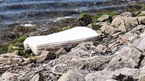 A discarded mattress is caught in the rock armour of SEP's riverside.